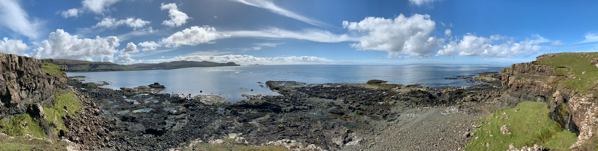 Panoramic View of a Rocky Beach and Grassy Cliffs